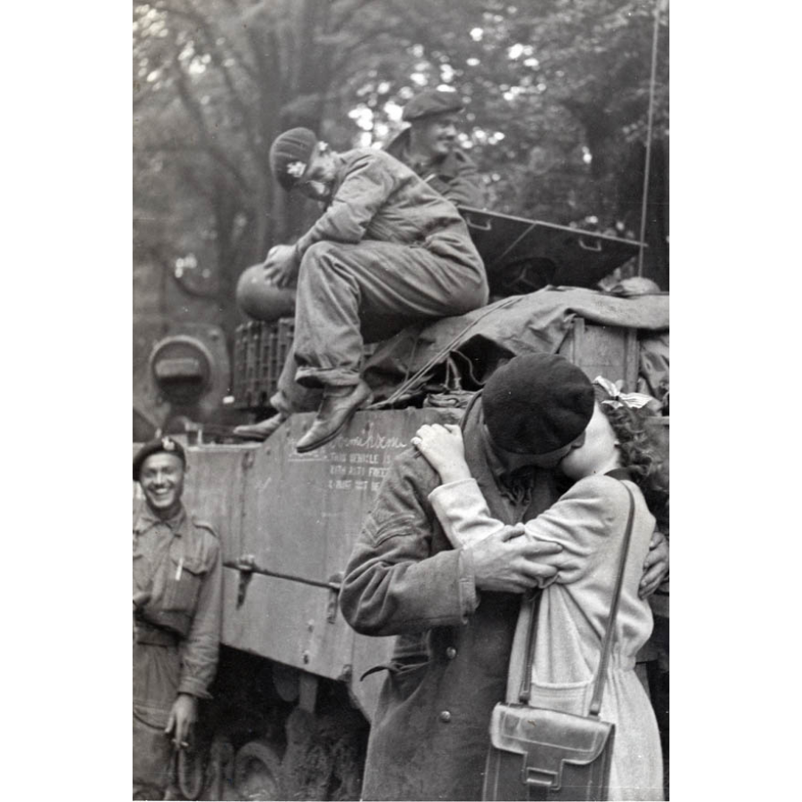 fo014522: Een kussend koppel voor een pantservoertuig bij de bevrijding tijdens de Tweede Wereldoorlog in Antwerpen, september 1944. © Louis Van Cauwenbergh